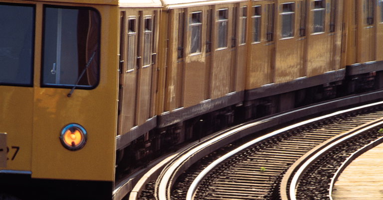 Vintage gold passenger rail car on a curved railway track
