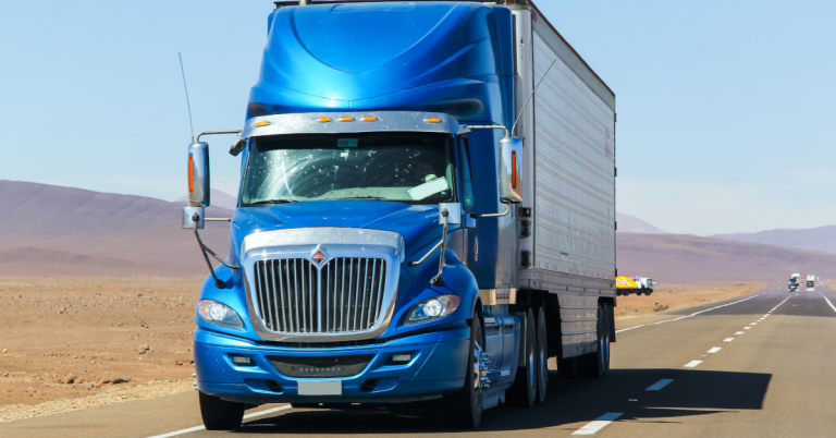 Blue International heavy-duty semi-truck tractor-trailer on a highway