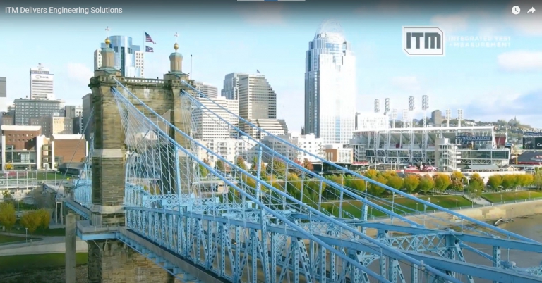 ITM Delivers Engineering Solutions banner over a photo of a teal suspension bridge and city skyline
